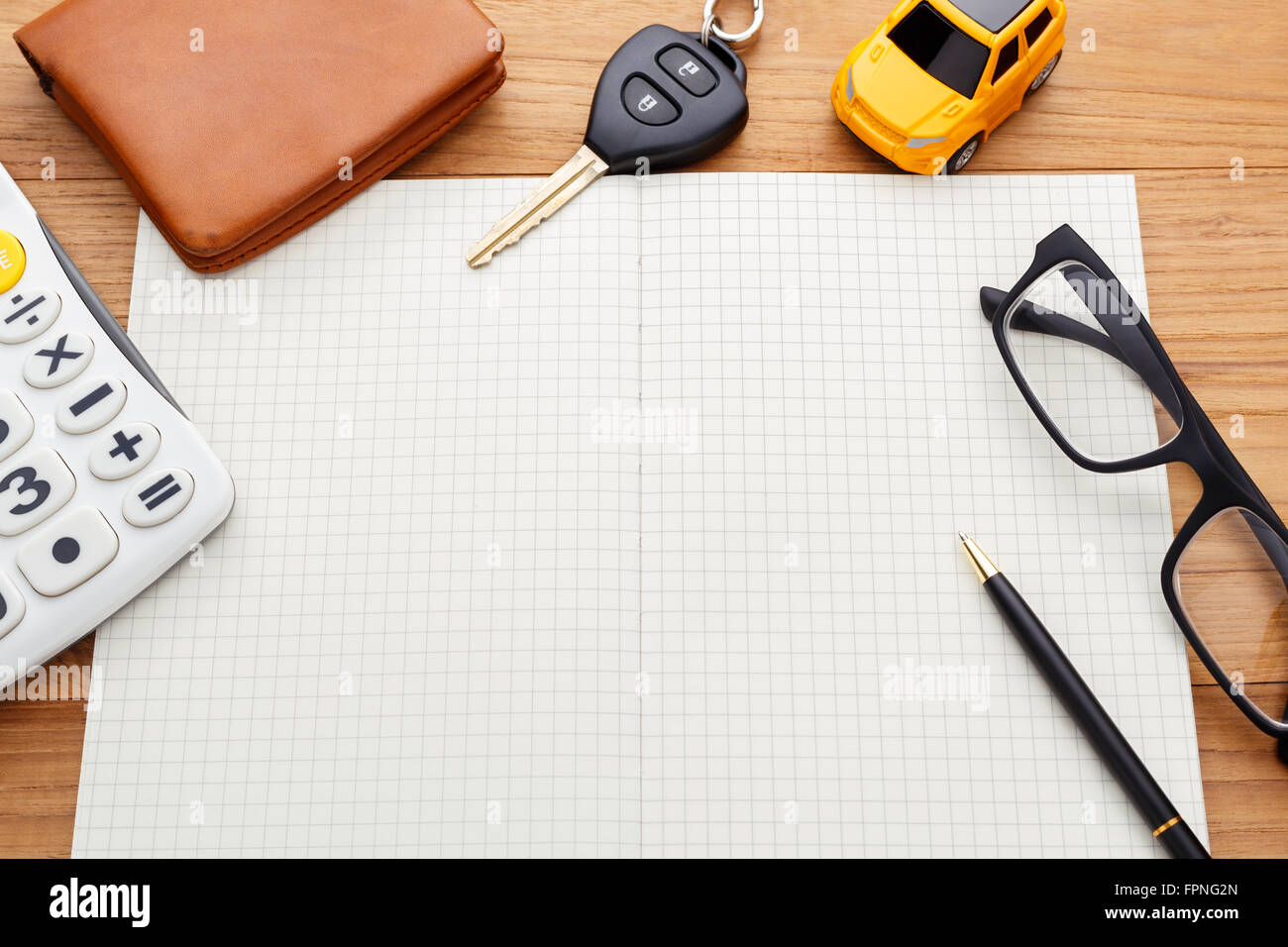 Chiave auto con la calcolatrice pocket money e penna sul notebook in bianco Foto Stock