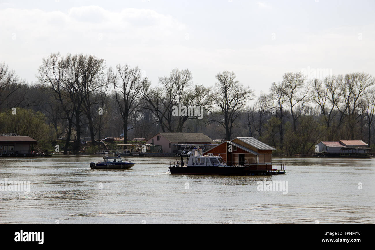 Fiume Sava, Belgrado - membri della polizia fluviale facendo sforzi per assumere il controllo di una zattera di disinserimento casa in un fiume correnti Foto Stock