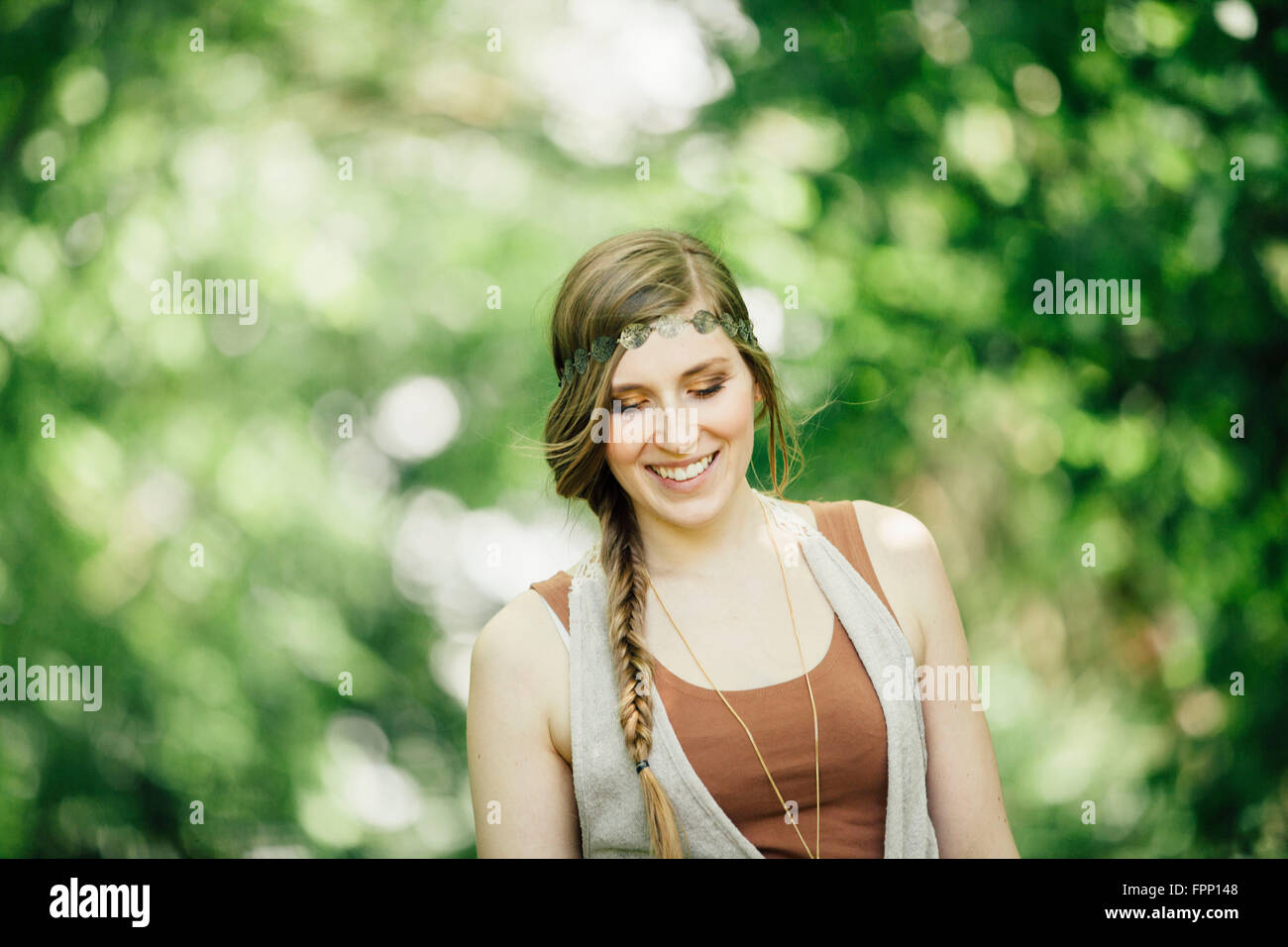 Giovane donna che guarda al suolo, sorridente, Foto Stock