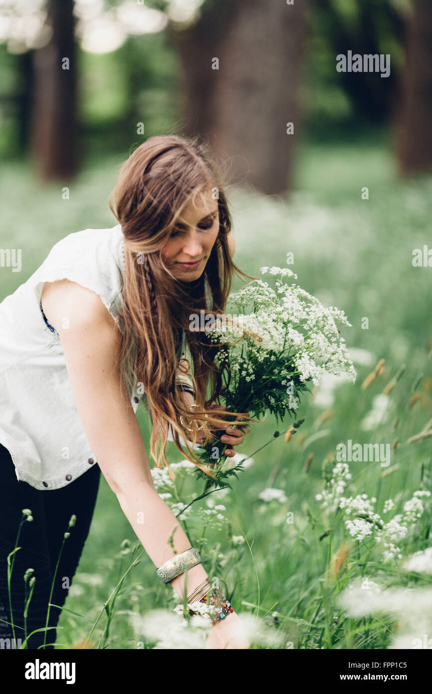 Giovane donna a caccia di fiori, Foto Stock