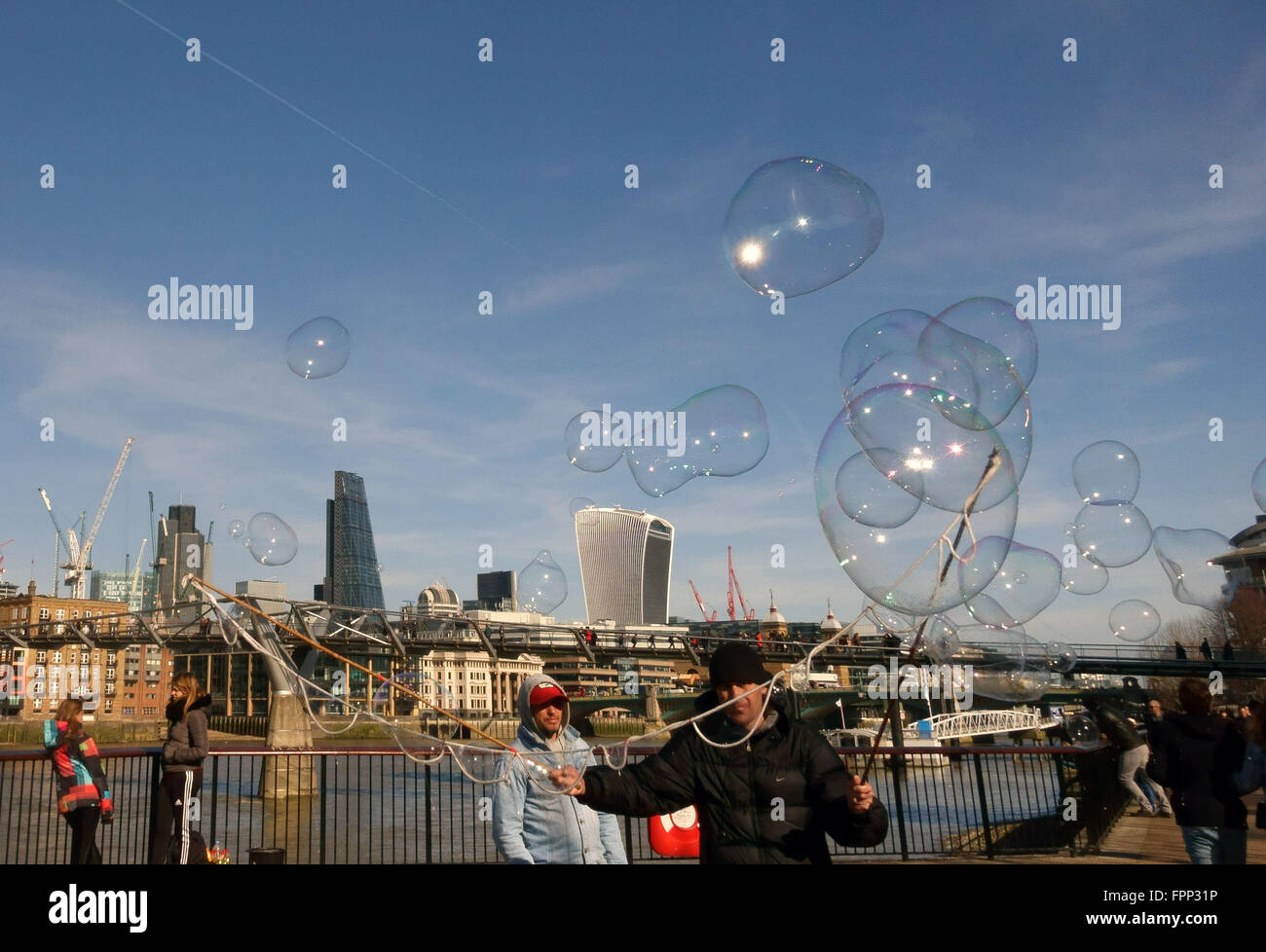 Soffiaggio in bolla intrattenitore di strada con la City of London skyline in background Foto Stock