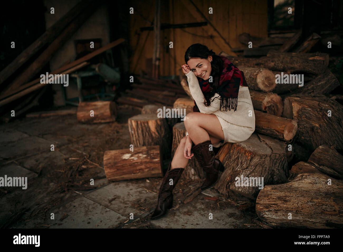 Donna seduta su tronchi di legno, felice, Foto Stock