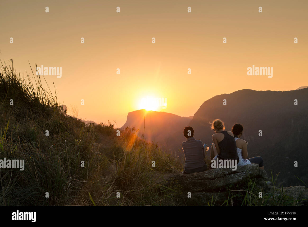 Tre escursionisti guardando le sunrise vista del Pedra Bonita nel Parco Nazionale della Tijuca, Rio de Janeiro, Brasile Foto Stock
