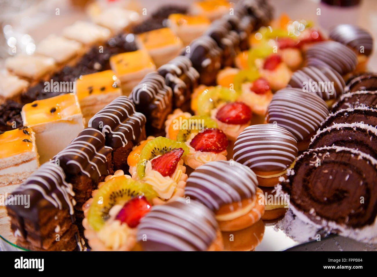 Diversi tipi di torte su una piastra e con luce laterale Foto Stock