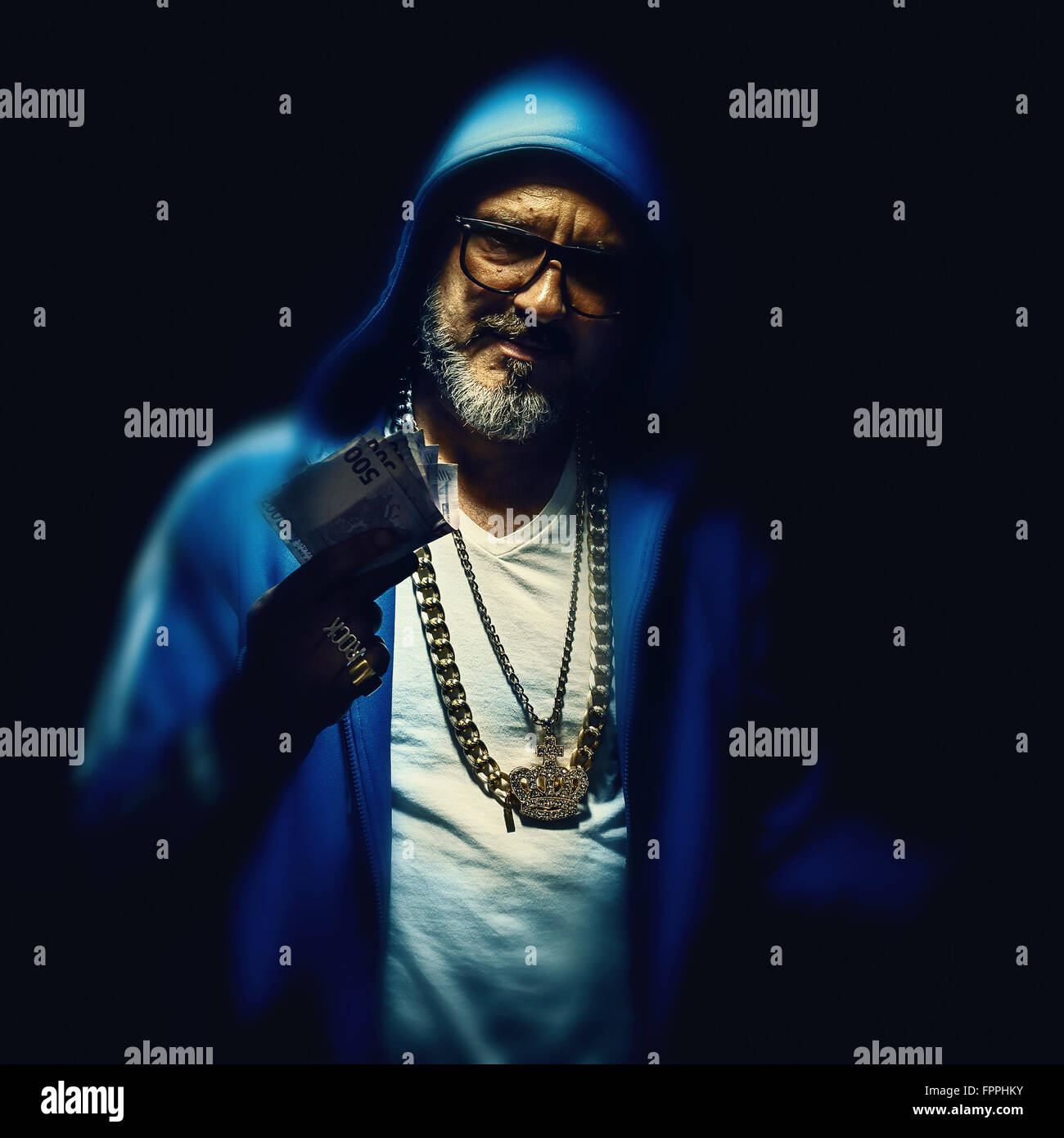 Ritratto di un uomo più anziano azienda Euro denaro, indossa una giacca blu. Hip-hop e stile urbano. Foto Stock