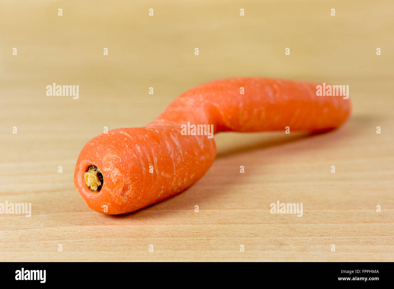 Deformato e deformato la carota sul tagliere Foto Stock