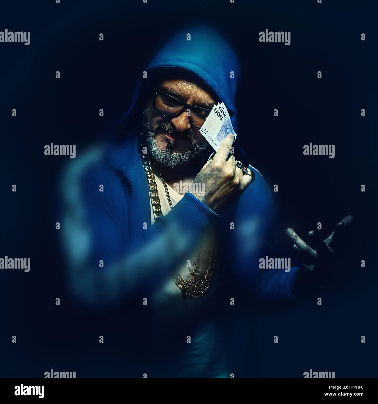 Ritratto di un uomo più anziano azienda Euro denaro, indossa una giacca blu. Hip-hop e stile urbano. Foto Stock
