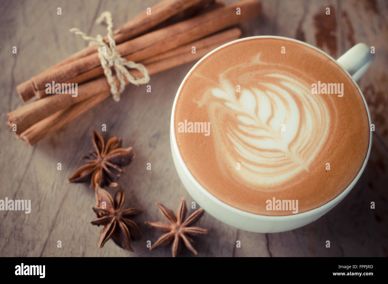 Una tazza di latte art su sfondo di legno, caffè vintage Foto Stock