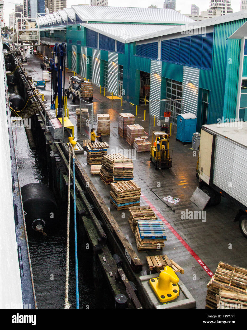 Un occupato dal caricamento dock a un terminal per navi da crociera in San Diego con i lavoratori calza la nave con i materiali di consumo. Foto Stock