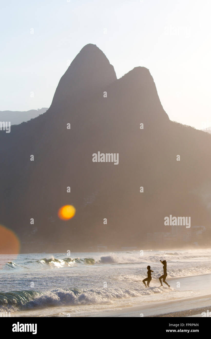 Gente del posto che entra nel mare sulla spiaggia di Ipanema a Rio de Janeiro Foto Stock