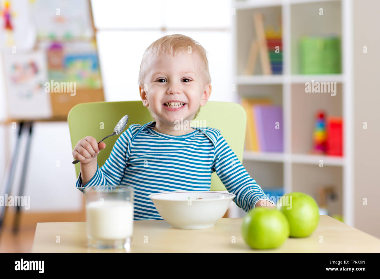 Kid mangiare cibo sano a casa o asilo nido Foto Stock