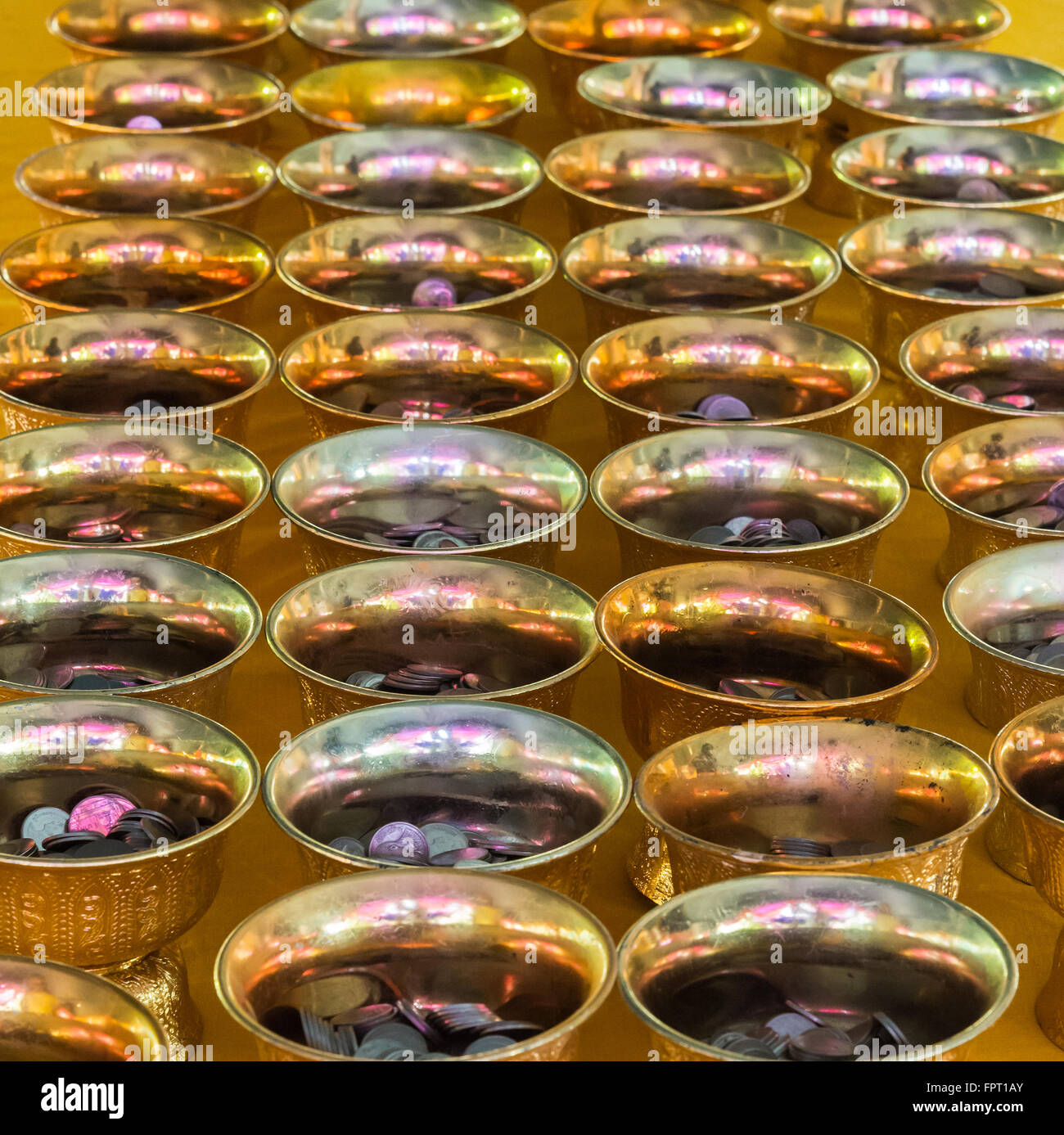 Vassoio d'oro piedistallo con piccola moneta per filantropia nel tempio thailandese. Foto Stock