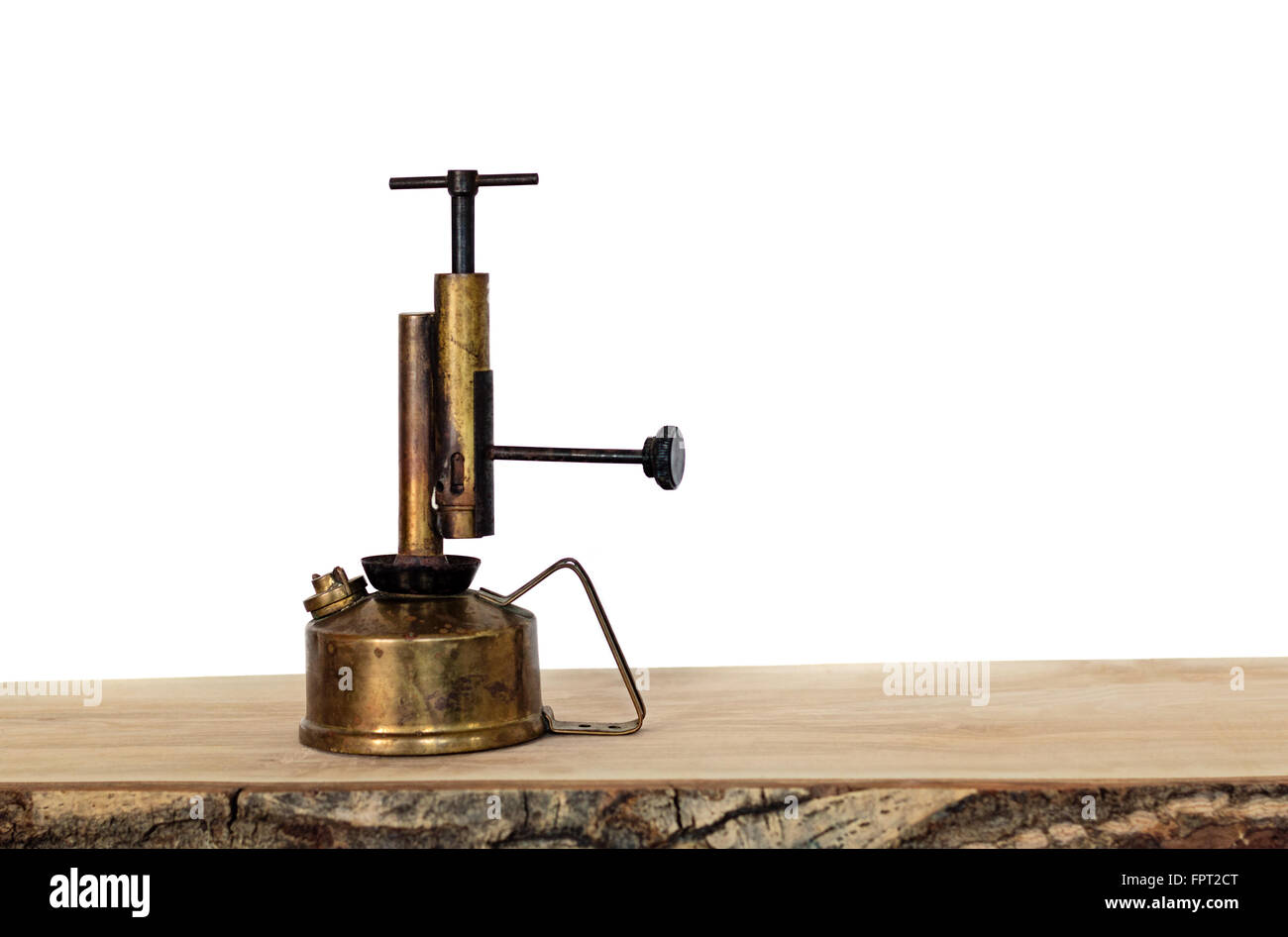 Ottone antico lampada a olio su una tavola di legno contro uno sfondo bianco. Foto Stock