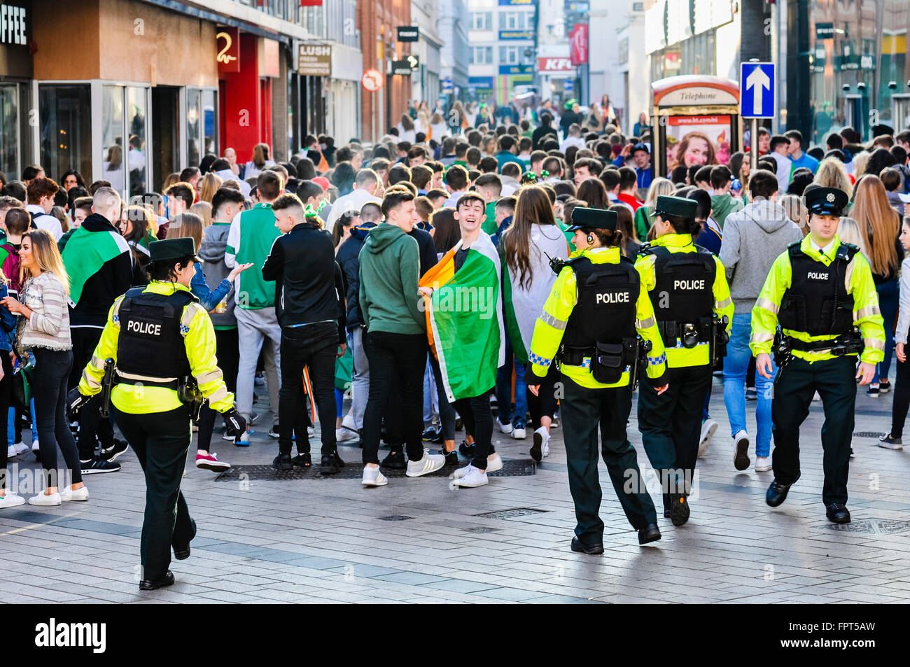 Belfast, Irlanda del Nord. 17 mar 2016 - PSNI funzionari di polizia si muovono su una grande folla di adolescenti che si erano riuniti a bere a Belfast City Centre durante la festa di San Patrizio. Foto Stock