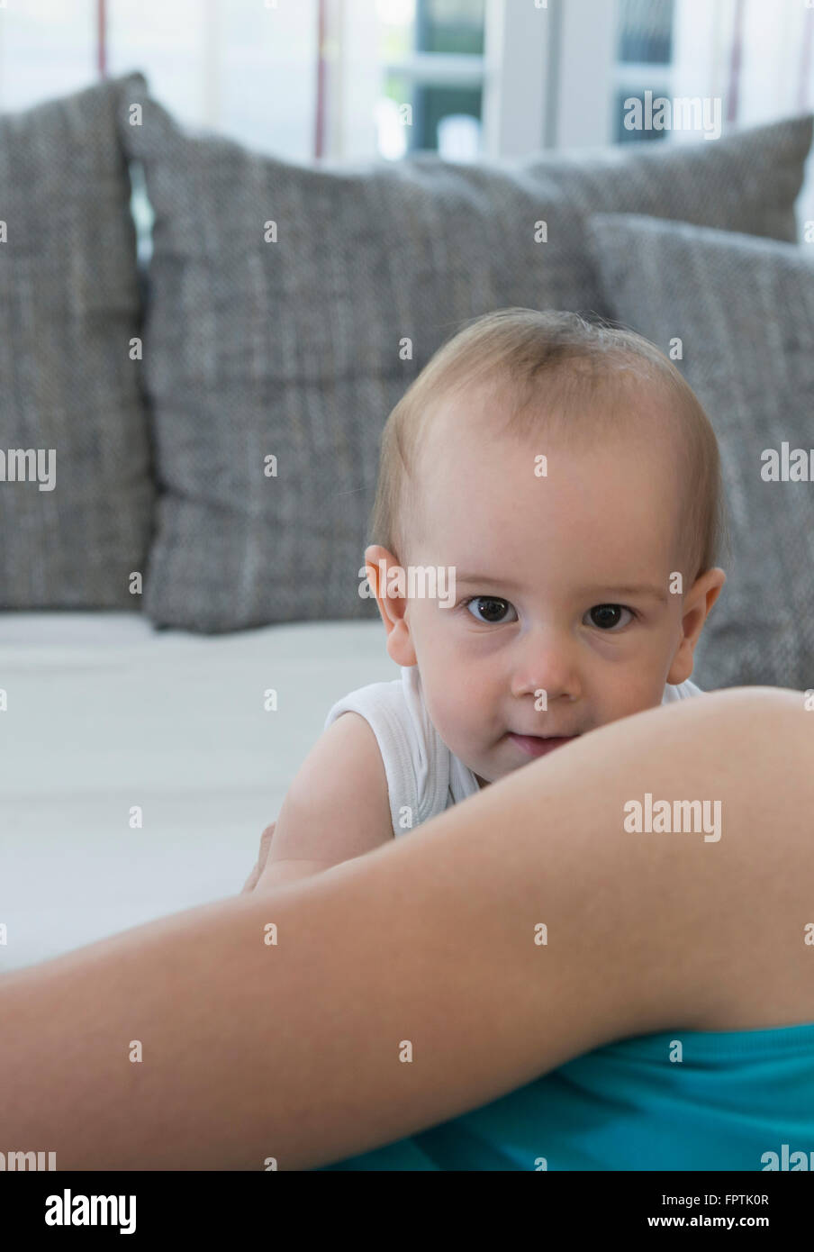 Carino baby boy nascondersi dietro la sua madre, Monaco di Baviera, Germania Foto Stock