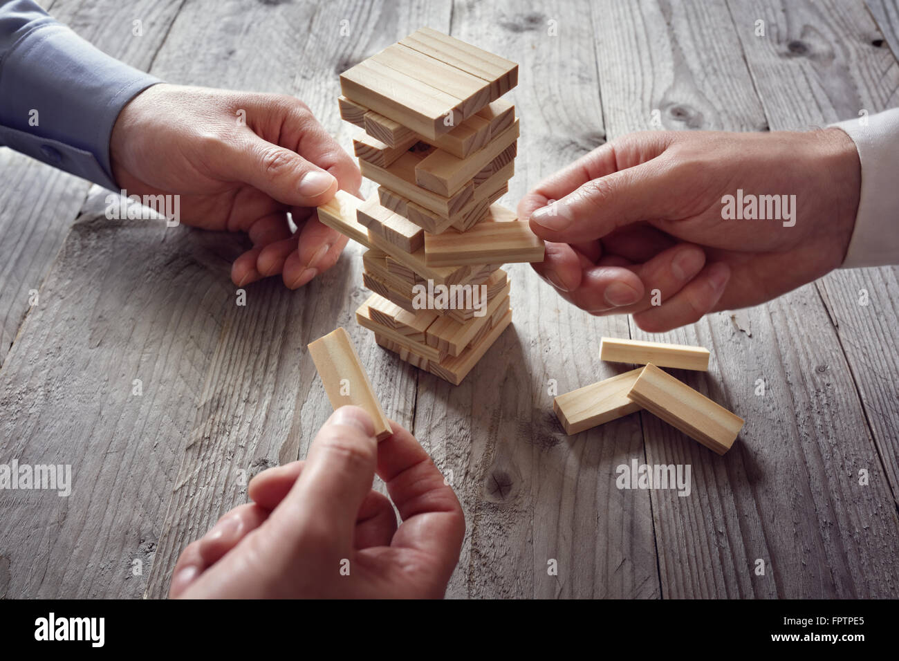 Pianificazione, rischio e strategia del team in business, imprenditore il gioco d'azzardo posizionando il blocco di legno su una torre Foto Stock