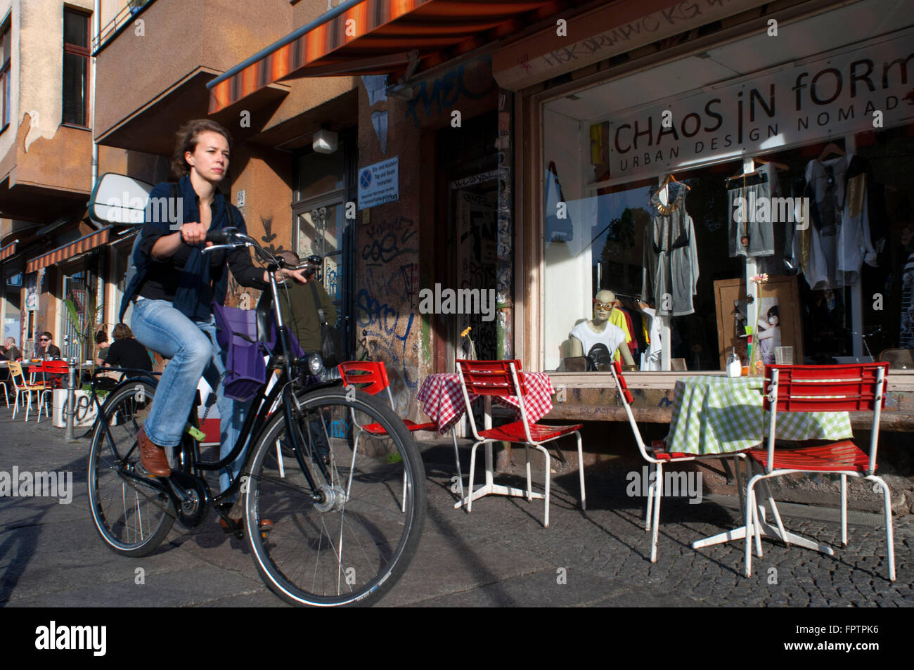 Donna in bicicletta nella parte anteriore del caos in forma shop a Kreuzberg. Falkenstein Street vicino a Ponte Oberbaum, Design Store, Club di scena, Foto Stock