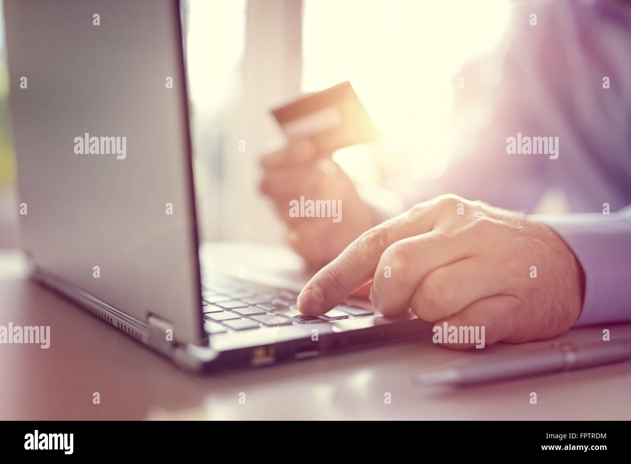 Uomo con carta di credito utilizzando un computer portatile per gli acquisti su internet Foto Stock
