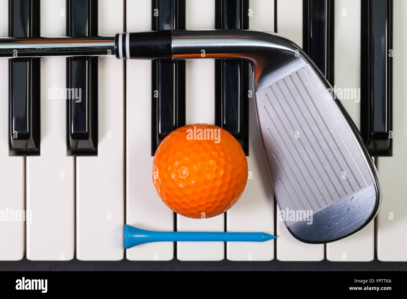 Virtuosi di gioco - Una tastiera di pianoforte e diverse attrezzature da golf Foto Stock