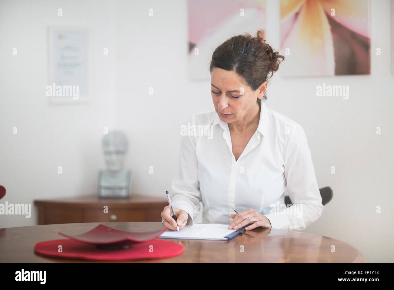 Medico donna prescrizione di scrittura in ospedale, Freiburg im Breisgau, Baden-Württemberg, Germania Foto Stock