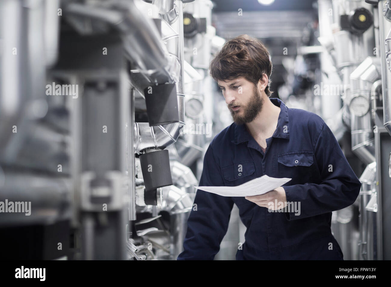 Giovane maschio ingegnere in un impianto industriale di Freiburg im Breisgau, Baden-Württemberg, Germania Foto Stock