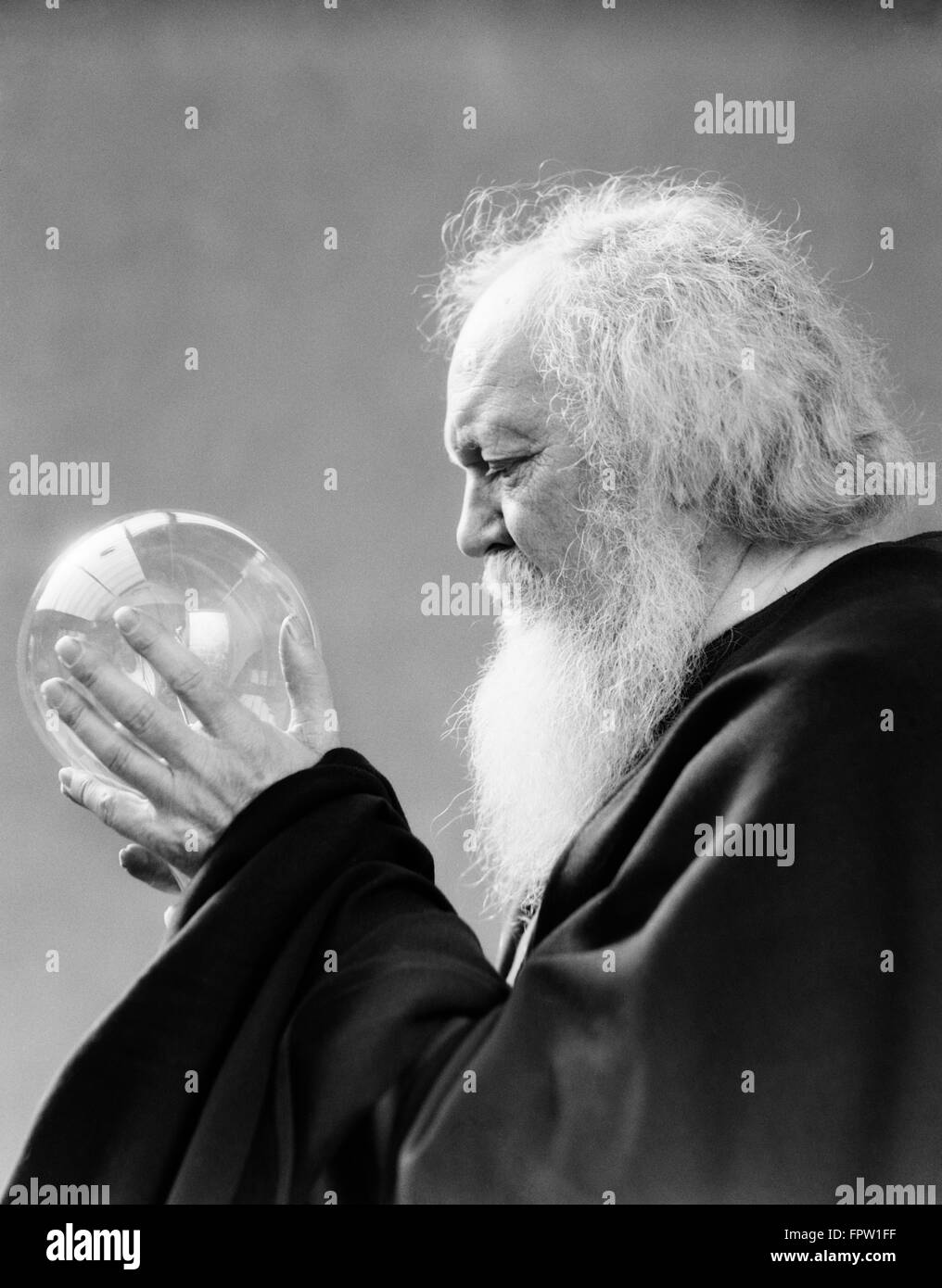 1930s uomo anziano barba bianca tenendo il vetro cristallo SFERA IN MANI MYSTIC FORTUNE TELLER Foto Stock