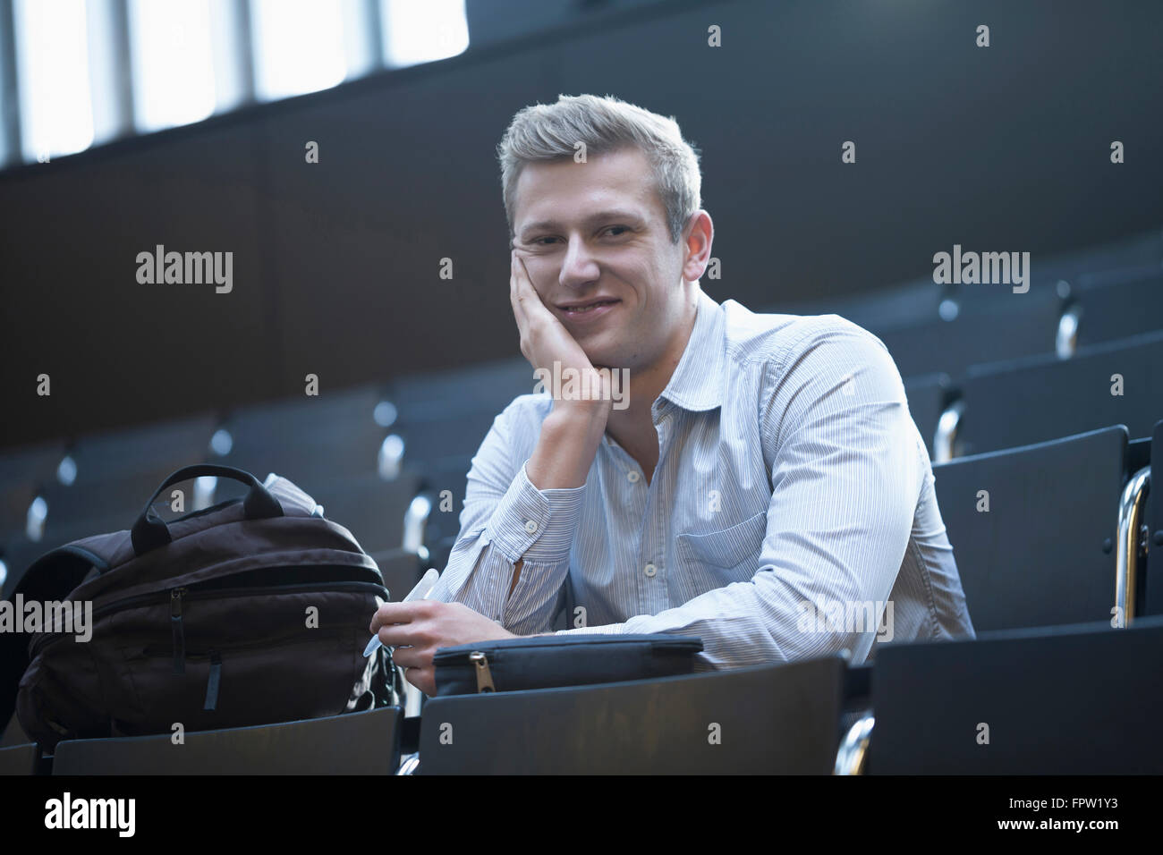 Ritratto di uno studente universitario seduto nella sala conferenze e nella lezione di ascolto, Friburgo in Breisgau, Baden-Württemberg, Germania Foto Stock