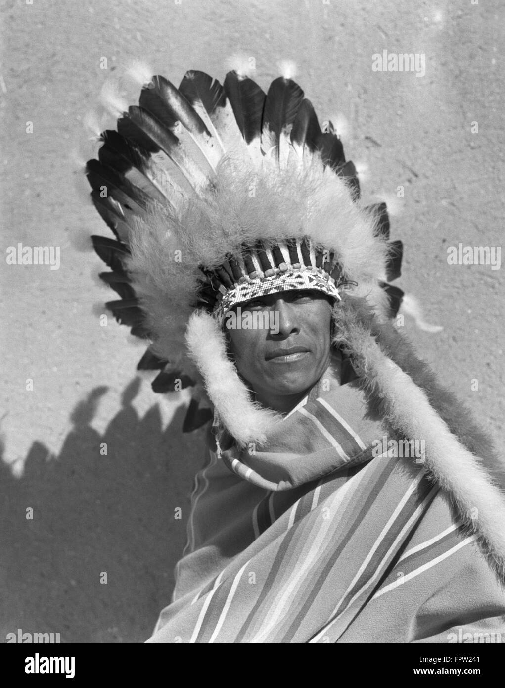 1930s ritratto Native American Indian uomo che indossa la piena FEATHERED acconciatura di cofano di guerra SAN ILDEFONSO PUEBLO NEL NUOVO MESSICO USA Foto Stock