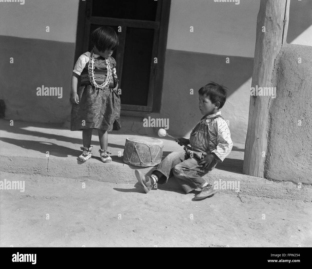 Negli anni Trenta due Native American bambini ragazzo e ragazza che gioca con il tamburo di San Ildefonso PUEBLO NEL NUOVO MESSICO USA Foto Stock