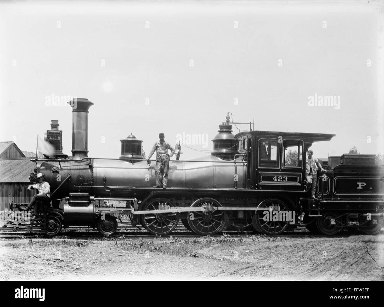 1900s tre uomini lavoratori in piedi sul treno a vapore Foto Stock