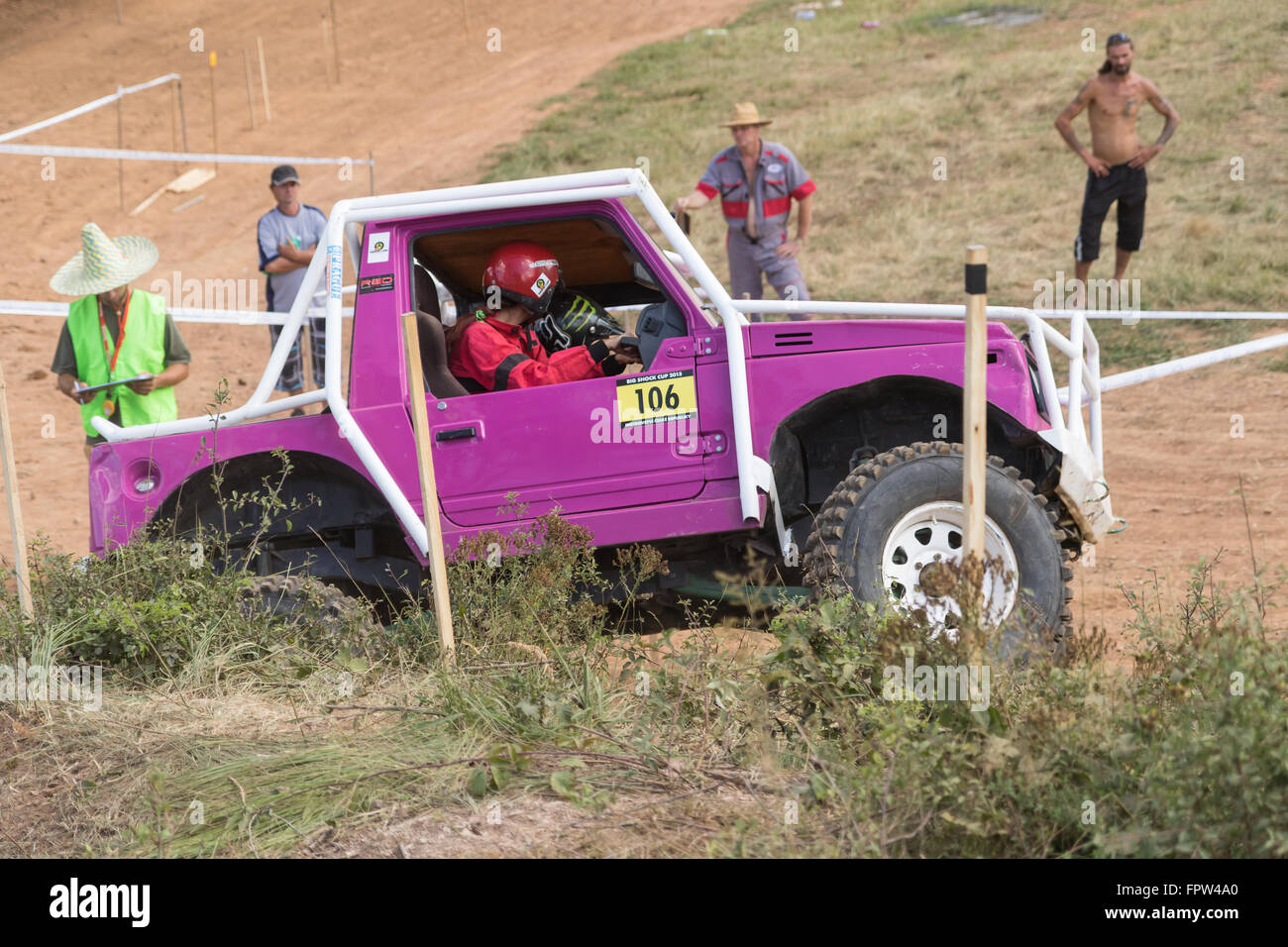 Vista laterale della piccola viola off road auto nel percorso definito tra i bastoncini di legno al concorso Foto Stock