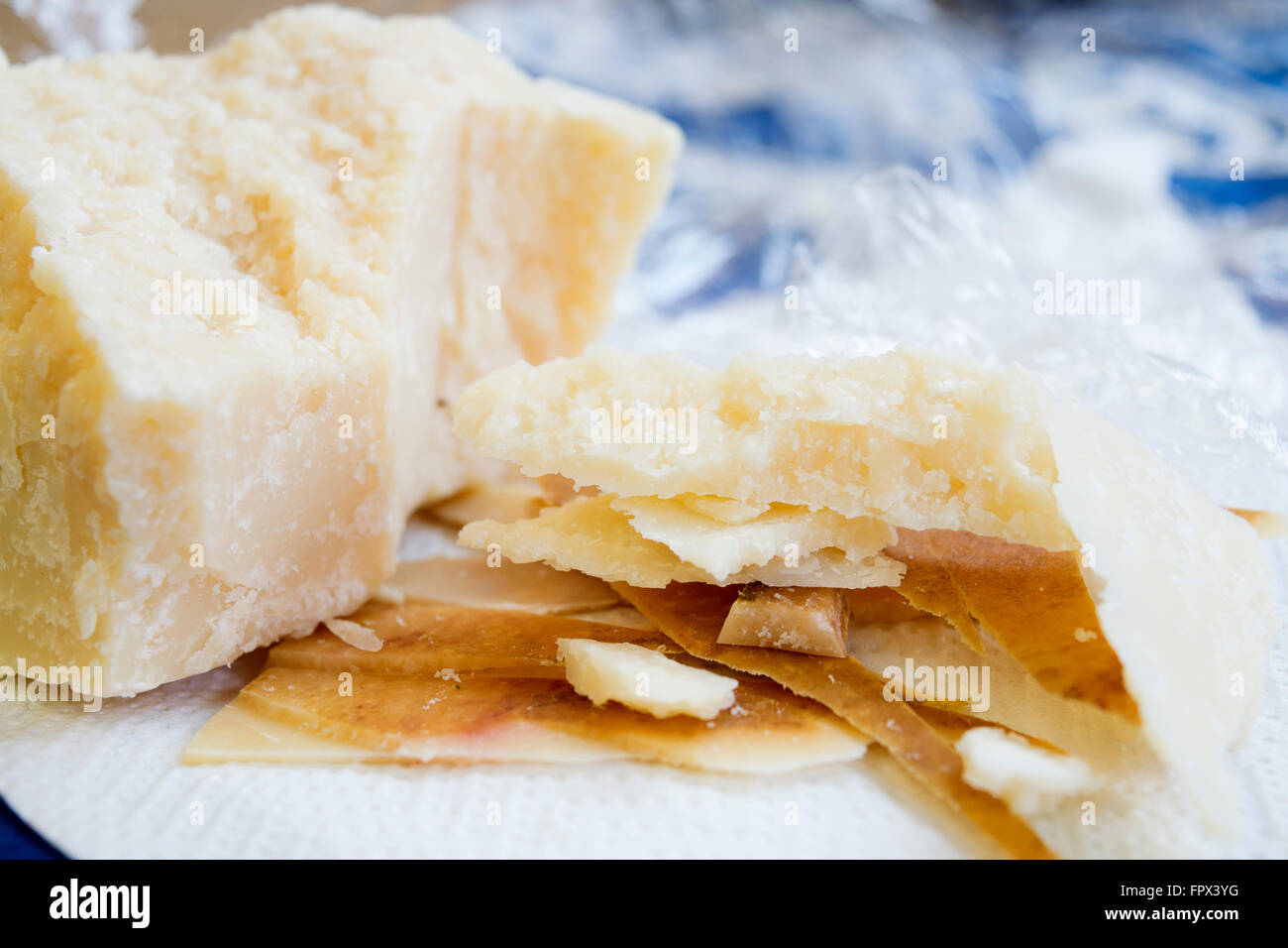Pezzi e la crosta del formaggio parmigiano con vicino un grosso pezzo di cuore Foto Stock