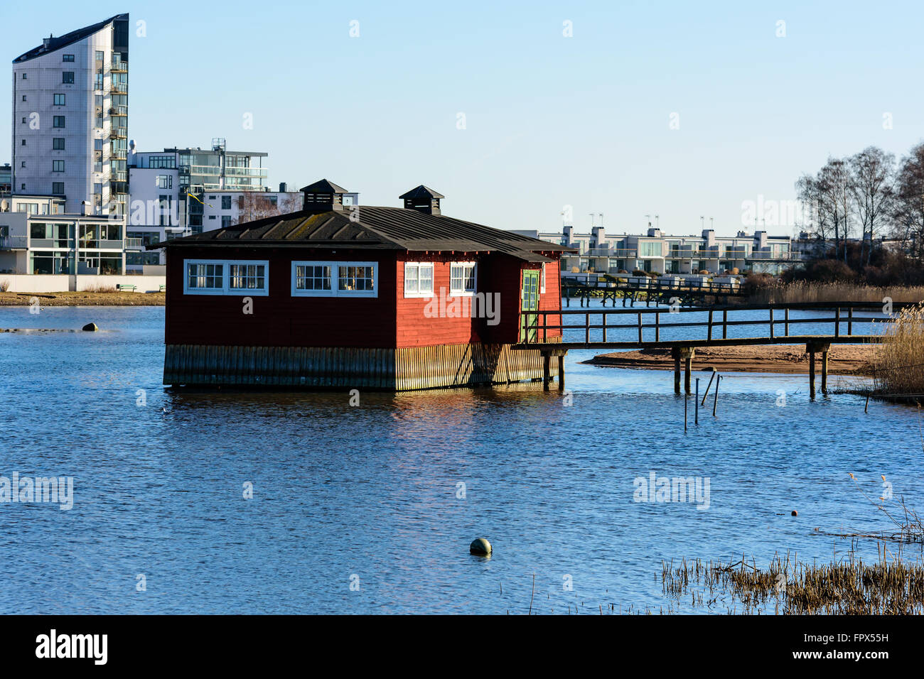 Kalmar, Svezia - 17 Marzo 2016: un vecchio stabilimento balneare alla fine di un molo in legno. Il colore rosso brillante, edificio in legno stand su palafitte ho Foto Stock