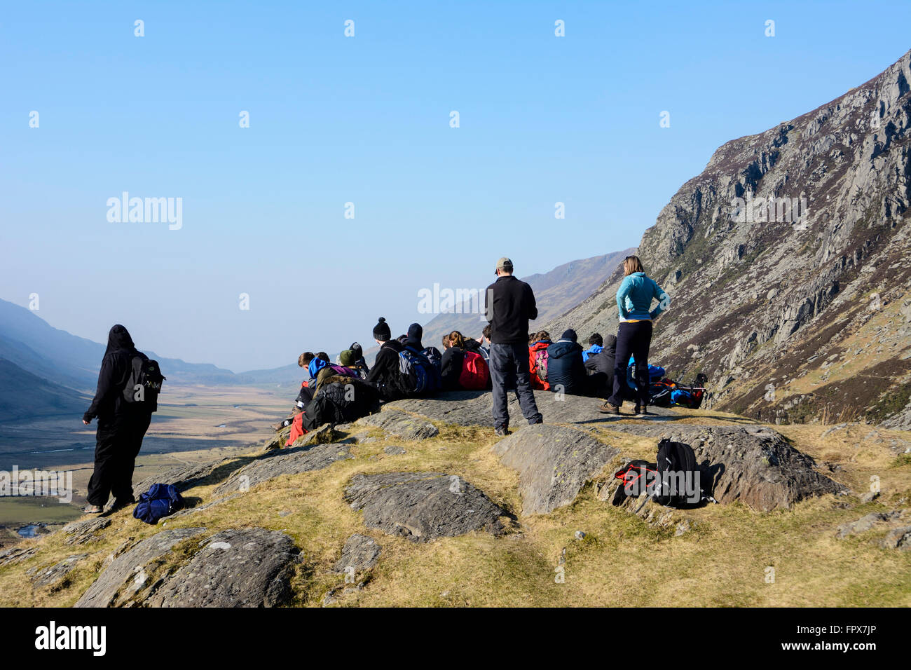 Un gruppo di escursionisti in appoggio e ejoying la vista verso il basso del Nant Ffrancon passano in Snowdonia con penna yr Ole Wen montagna. Foto Stock