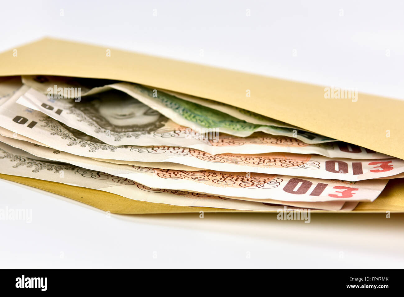 Mazzetta di banconote in Sterlina Inglese valuta in busta marrone Foto Stock