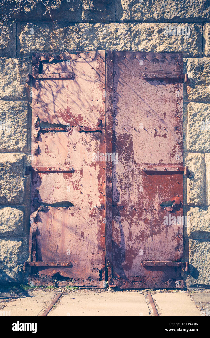 Una vecchia porta di ferro arrugginito è fuori in un antico fortilizio militare. Foto Stock