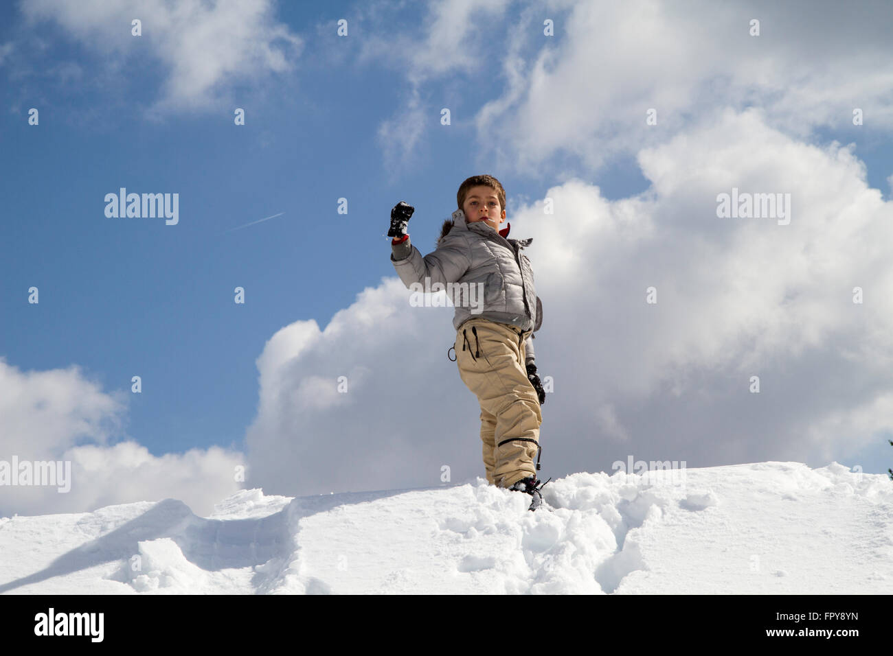 Bambino in snow hill saluto, cielo blu Foto Stock