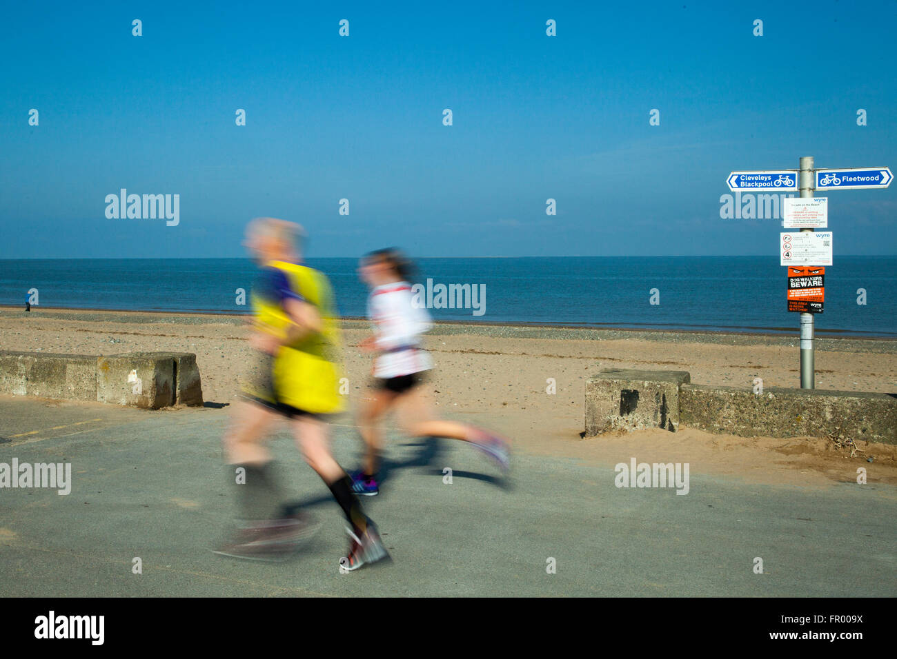 Fleetwood lungomare corsa; corridori sfocati in movimento sulla spianata costiera. Velocità di esecuzione di 10k Charity. I corridori si sono riuniti sul lungomare per una corsa di beneficenza organizzata dal Rotary Club di Fleetwood, Lancashire, Regno Unito Foto Stock