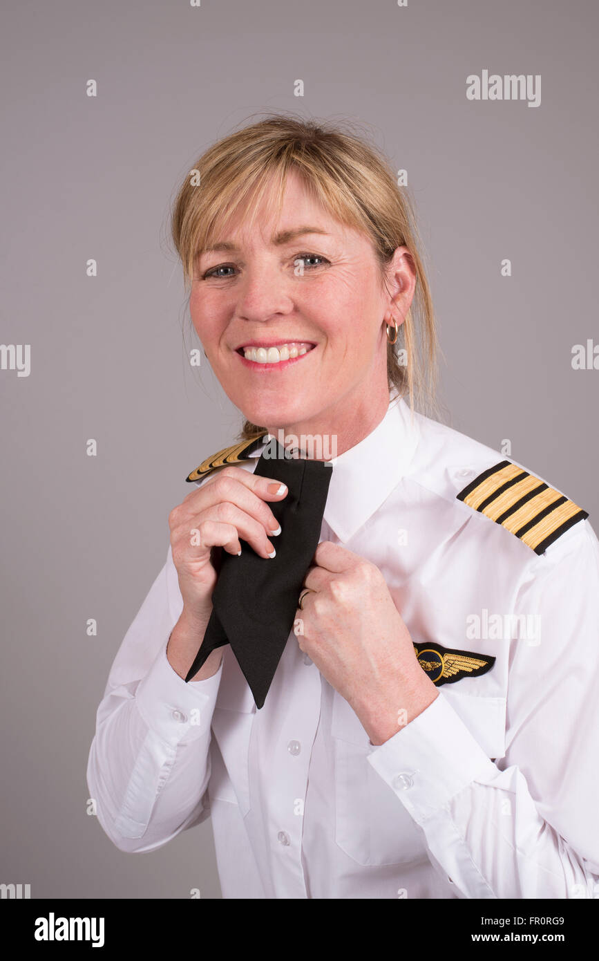 Senior compagnia femminile capitano clipping lei cravat uniforme sulla sua maglietta Foto Stock