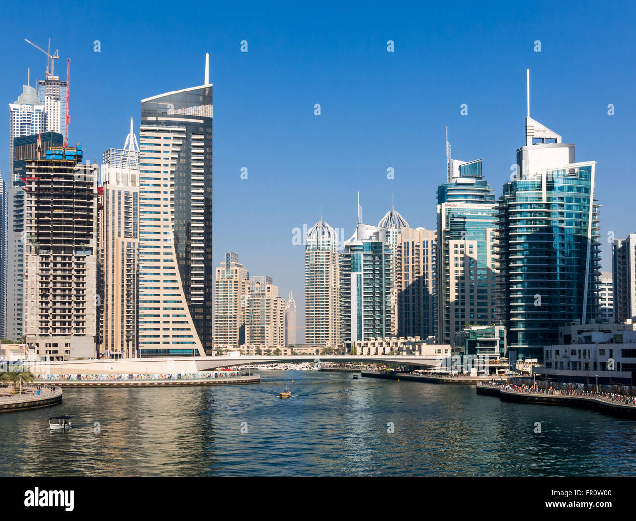 Highrise waterfront edifici, barche e ponte nel quartiere di Marina di Dubai, Emirati Arabi Uniti Foto Stock