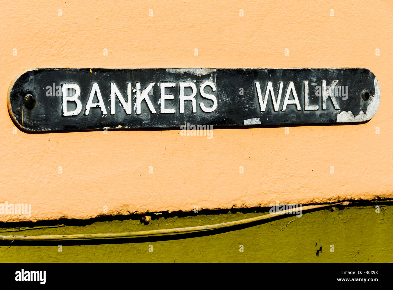 Strada segno, 'Banchieri a piedi su un grungy muro di casa. Foto Stock