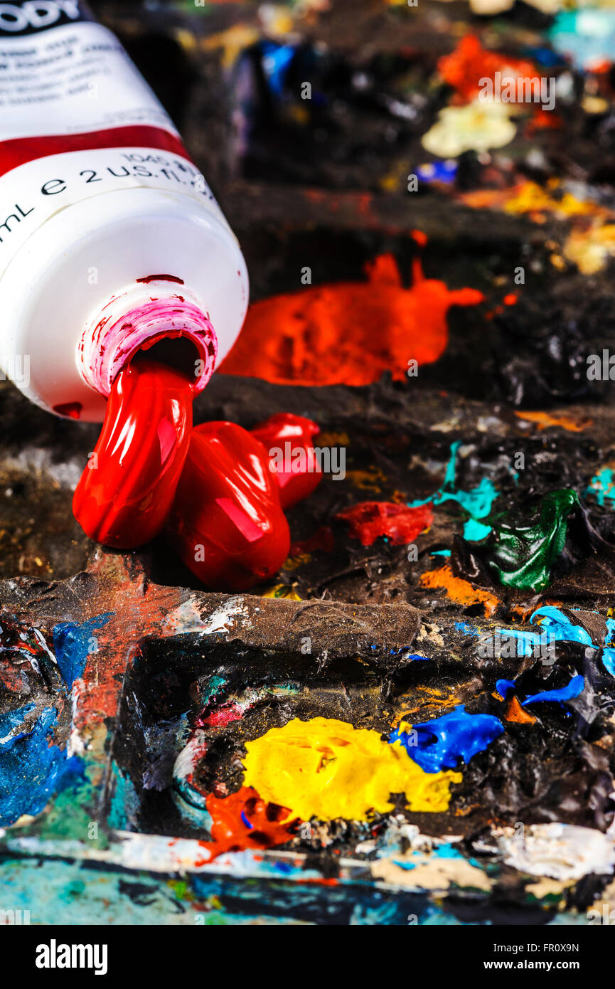 La vernice rossa schiacciata su una tavolozza degli artisti. Foto Stock