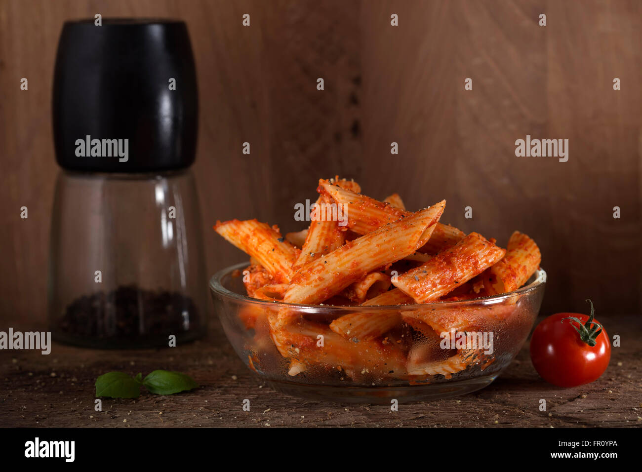 Penne pasta in salsa di pomodoro con carne e i pomodori su un sfondo di legno Foto Stock