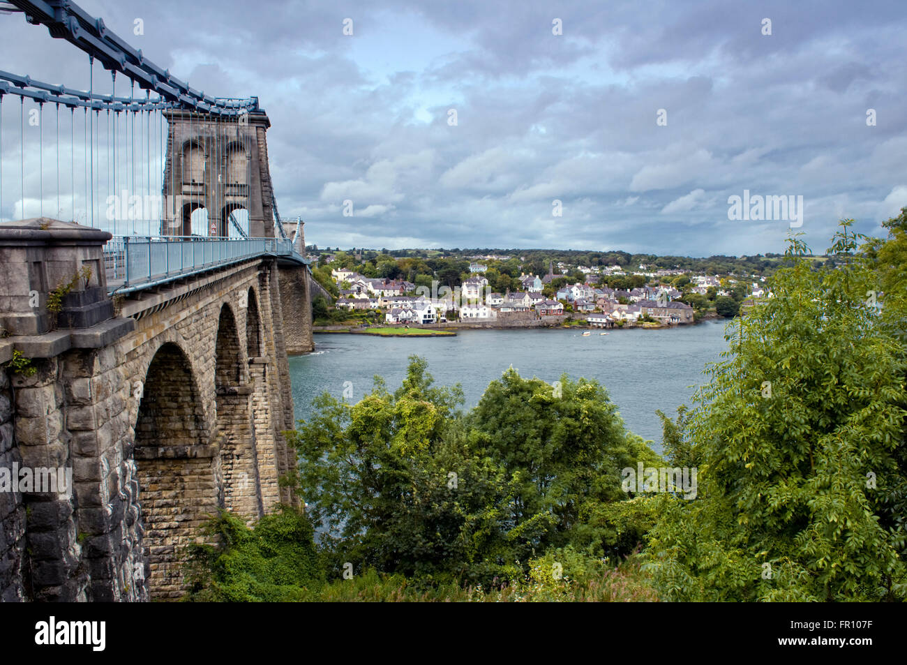 Menai Bridge crossing Menai Straits di Anglesey dalla terraferma in Galles, UK, progettato da Thomas Telford Foto Stock