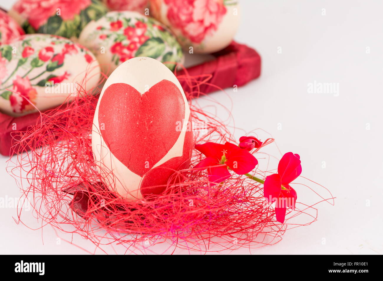 Decoupage decorato uovo di Pasqua sulla paglia rosso Foto Stock