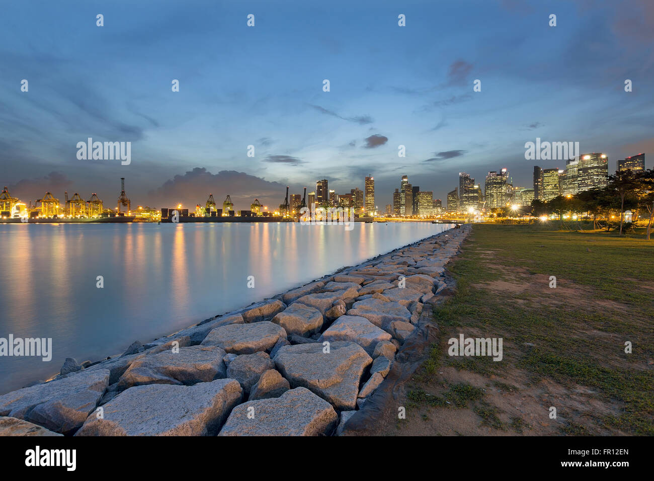 Porto di Singapore e dello skyline della città lungo il Fiume Singapore di Notte Foto Stock