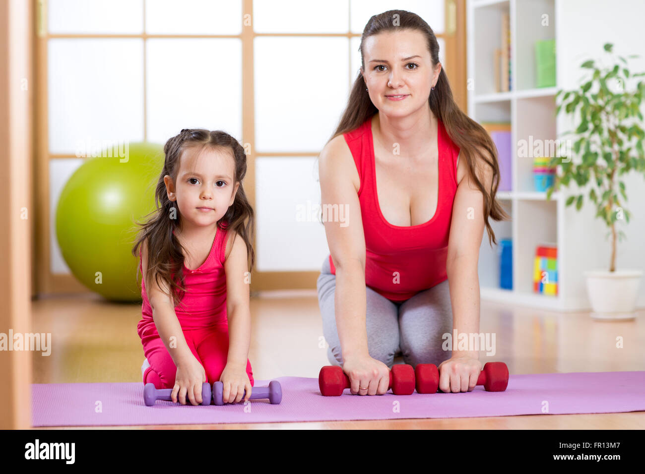 Donna con bambino facendo palestra e fitness esercizi Foto Stock
