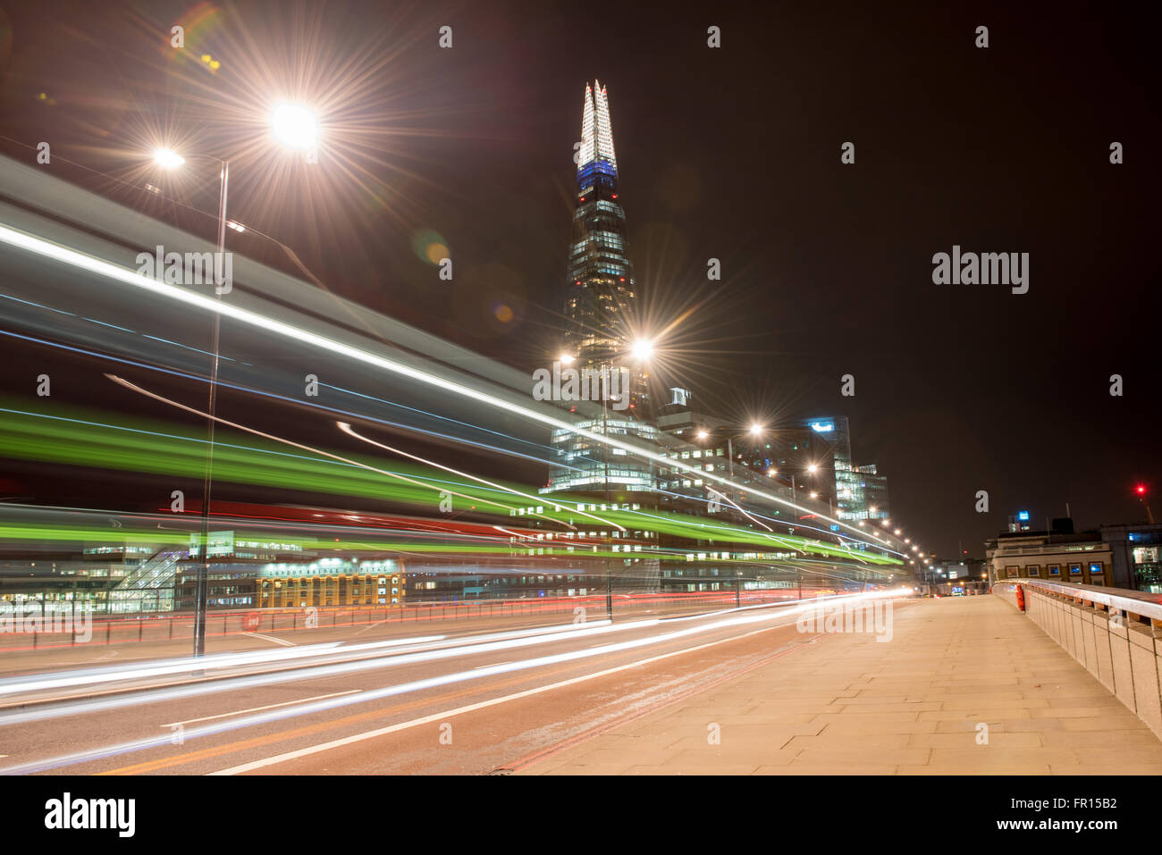 La Shard e Ponte di Londra di notte colorato double decker bus sentieri di luce a Londra, Regno Unito. Foto Stock