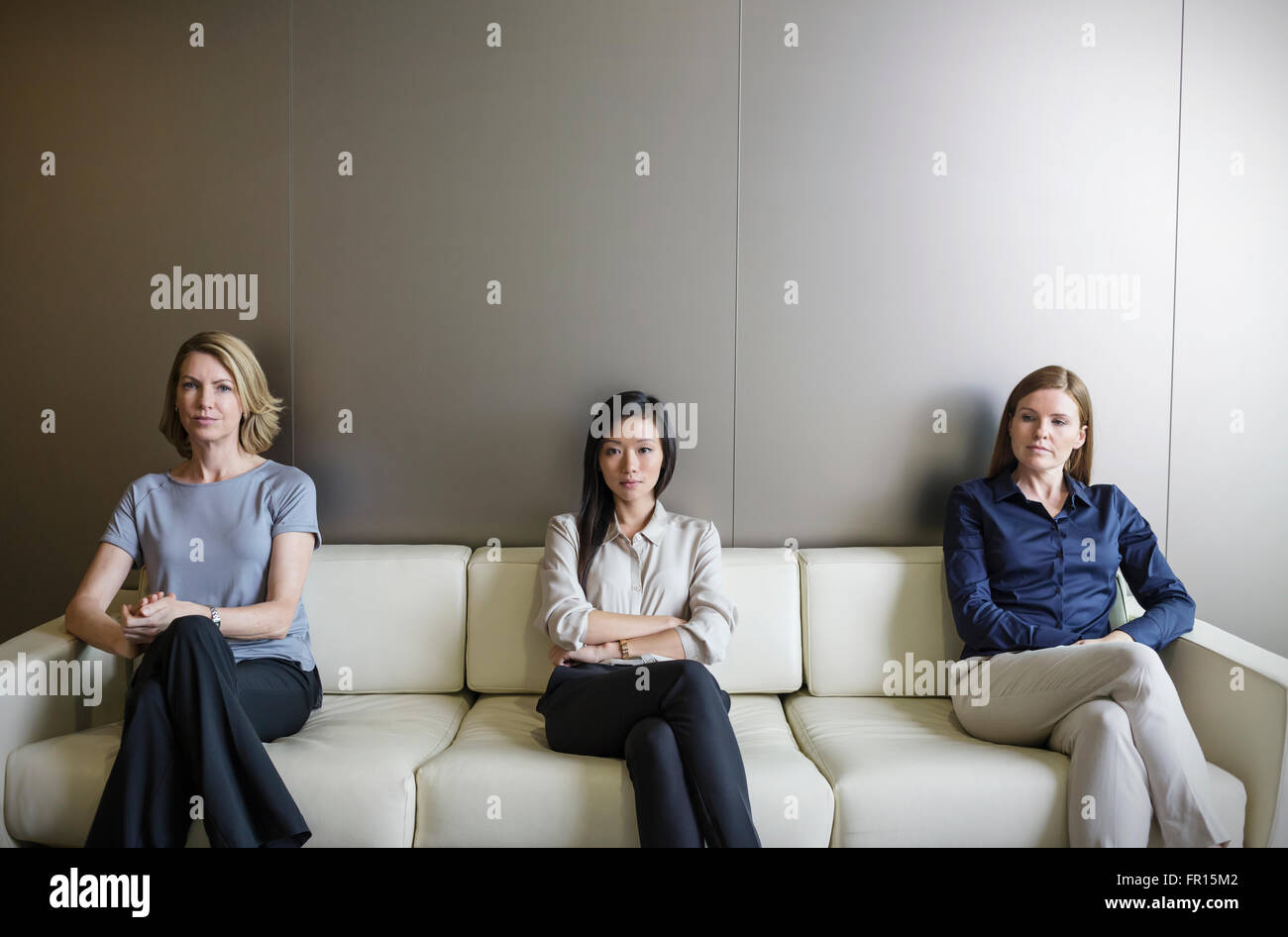 Ritratto di gravi imprenditrici in attesa sul divano Foto Stock