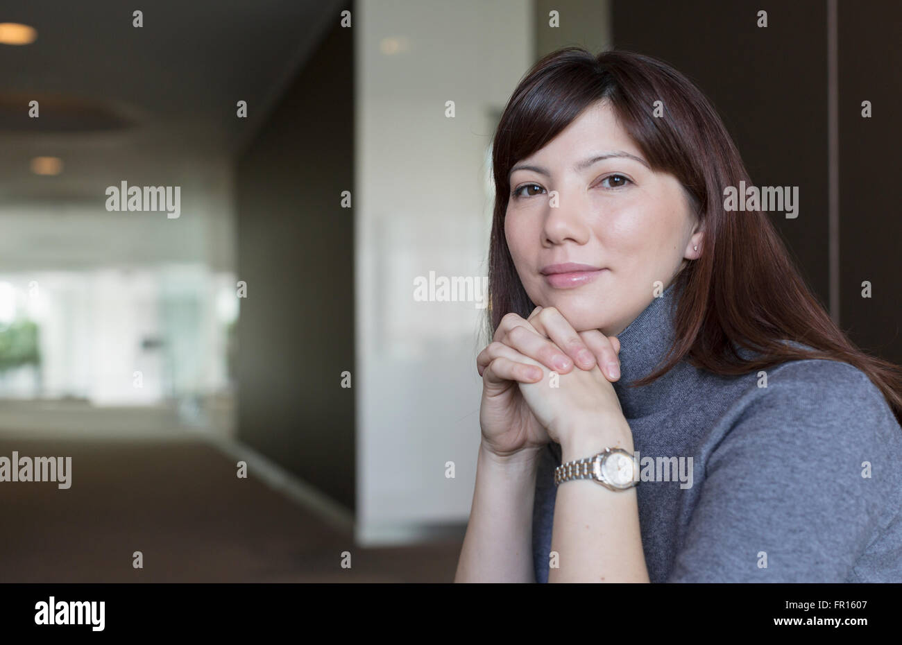 Ritratto fiducioso imprenditrice con le mani incrociate Foto Stock